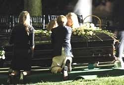 Sen. Edward Kennedy's grandchildren and family members kneel over his coffin during his burial service at Arlington National Cemetery in Arlington, Va