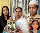 Shamima Kausar, mother of Ishrat Jahan (inset), holds a group photo of the family while standing with her daughter and son in Thane, Monday. PTI