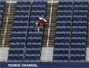 Spectators sit in Arthur Ashe Stadium waiting for play to commence despite the heavy rain at the US Open tennis tournament in New York.
