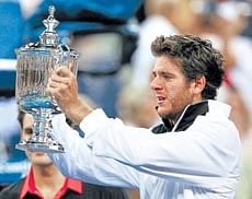 TRIUMPH AND TEARS: Juan Martin Del Potro of Argentina takes a good look at his prize after defeating Roger Federer in the US Open final on Monday. AFP