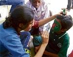 Helping hand: A boy gets his face painted by an NGO member.