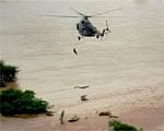 An Indian Air Force rescue helicopter lifts a man from a flooded area of Raichur district on Saturday. PTI