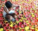 A worker paints final touches on earthen lamps in Amritsar on Saturday. AFP