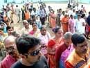 Voters wait outside a polling booth to cast their votes for the state assembly elections, in Mumbai on Tuesday. PTI