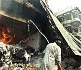 A volunteer extinguishes fire at  market following the car bomb blast in Peshawar on Wednesday. AFP
