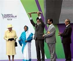 Britain's Queen Elizabeth II, President Pratibha Patil, Organising Committee of CWG, Suresh Kalmadi look on as Sports Minister M S Gill displays the
