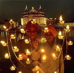 Sikh children light lamps at Golden Temple in Amritsar on Monday on the occasion of birth anniversary Guru Nanak. PTI