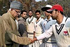 Union Minister of New and Renewable Energy and President of the J and K CA Farooq Abdullah shakes hands with J&K  team before the Ranji match.