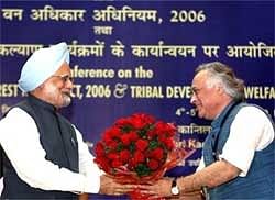 Manmohan Singh welcomed by Jairam Ramesh at the meeting of Chief Ministers and State Ministers for forests and tribal development in New Delhi. PTI