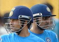 Indian cricketer Sachin Tendulkar (L) and Virender Sehwag look on as they wait for their turn to bat during a practice session