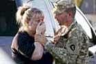 Sgt Anthony Sills comforts his wife as they wait outside the army base .