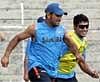 : Indian cricketers Mahendra Singh Dhoni and Ravindra Jadeja play football during a practice session at Guwahati. PTI