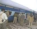Indian police officers inspect the derailed coaches of a New Delhi-bound Mandore Express that derailed near Banshkov, south of Jaipur, on Saturday. AP