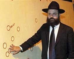 Rabbi Avraham Berkowitz, Director of the Chabad Mumbai Relief Fund, showing bullet marks on a wall right opposite Nariman House during a multi-faith candle light vigil in the memory of 26/11 terror attacks victims in Mumbai on Tuesday. Nariman House is the Jewish center where the terrorists killed a rabbi, his wife and a National Security Guard commando in 2008. PTI