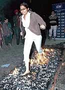 A corporate employee walks over embers during a workshop in Amritsar on Thursday night. PTI