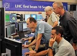 In this Sept. 10, 2008 file photo, European Center for Nuclear Research (CERN) scientists control computer screens showing traces on Atlas experiment of the first protons injected in the Large Hadron Collider (LHC) during its switch on operation in CERN's control room, near Geneva, Switzerland. Scientists switched on the world's largest atom smasher for the first time on Friday. AP