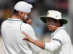 lets try this: Sachin Tendulkar (right) gives some tips to Harbhajan Singh  as the off-spinner struggles for impact on a placid pitch during the first Test against Sri Lanka at the Sardar Patel Gujarat Stadium in Ahmedabad. AFP