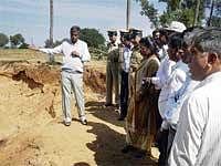 Tightening Screws: Deputy Commissioner Anwar Pasha inspecting sand mining in farm lands in Gauribidanur taluk on Tuesday. DH Photo