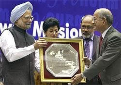 Prime Minister Manmohan Singh presents the JNNURM Award for Excellence for Urban Transport Projects to Delhi Metro Rail Corporation in New Delhi on Thursday. PTI