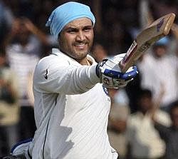 Indian cricketer Virender Sehwag acknowledges the crowd after scoring a double century during the second day of the third cricket test match between India and Sri Lanka in Mumbai, India,