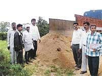 Officials of Mines and Geology Department seizing a lorry transporting sand  near Thammireddyhalli in Mulbagal taluk on Wednesday. DH Photo