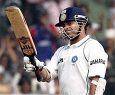 Sachin Tendulkar raises his bat after completing his half-century on Friday. AP