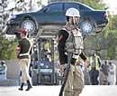 A military policeman keeps guard as a car is removed from the site of a mosque attack in Rawalpindi on Friday. Reuters