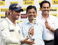 The Indian team captain Mahendra Singh Dhoni receives Test Series Trophy from Professor Ratnakar Shetty and former cricketer D Vengsarkar in Mumbai on Sunday. PTI