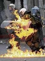 A policemans clothing catches fire after demonstrators threw petrol bombs in Athens on Sunday. AP