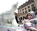 A child is seen next to a melting ice statue of a polar bear in the center of Copenhagen on Sunday. AP