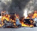 Burning vehicles are seen at the site of suicide bombing in Peshawar on Monday. AP