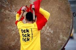 One of 20 Chinese traditional drummers wearing T-shirts bearing slogans "Save the climate, no time to waste" and "tck tck tck (time to act on climate change) Copenhagen" takes part in a Greenpeace event addressing world leaders in Copenhagen, in Beijing, Saturday. AP