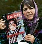 Peoples Democratic Party President Mehbooba Mufti holds up a magazine carrying the photo of one of the two Shopian victims, during a press conference in Srinagar on Tuesday. PTI