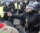 A Danish riot police officer uses pepper spray, as police push back protestors during a demonstration outside the Bella Center in Copenhagen. AP