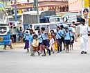 Stop And Proceed:  Students  attempting to negotiate a busy traffic  junction in Benniganahalli. DH Photo