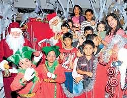 Children in Santa Claus attire, among others, are all smiles on the eve of  Christmas in Bangalore on Thursday. DH photo