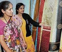 wEAVERS MAGIC Visitors admiring silk creations at the  National Handloom Expo at Palace Grounds in Bangalore on Thursday. DH photo