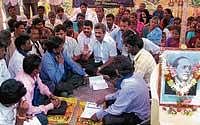 MLA D N Jeevaraj holding discussion with Karnataka Dalit Sangharsha Samiti members, who were staging a protest in front the taluk office in N R Pura on Friday.  dh photo