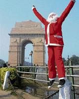 Merrymaking: A man dressed as Santa Claus cheers people during Christmas celebrations at India Gate in New Delhi on Friday. PTI