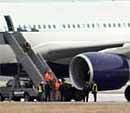 This image made from video shows security personnel dressed in protective clothing on the stairs of the Northwest Airlines Flight 253 on the runway after arriving at Detroit Metropolitan Airport from Amsterdam on Friday, Dec. 25, 2009 in Romulus, Mich.