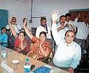 Virajpet Town Panchayat members M K Poovaiah, Maria Sequeira, Tara raising their hands during no-confidence motion against President K Kanthi Belliappa.  DH  photo