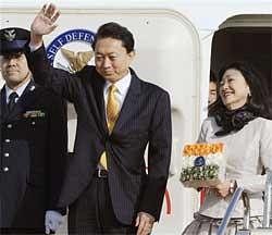 Japan's Prime Minister Yukio Hatoyama waves as his wife Miyuki looks on before boarding a special plane at Tokyo's Haneda airport on Sunday Dec. 27, 2009. Hatoyama left for India for talks with his Indian counterpart Manmohan Singh in New Delhi. AP