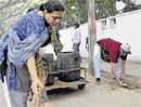 Frazer Town Residents Welfare Federation members sweeping road during Cleanliness Drive on Thursday. DH  photo