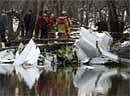Investigators look over the wreckage of a Royal Air cargo jet that crashed into the banks of the Des Plaines River in a forest preserve near Wheeling, Ill. on Tuesday. AP Photo