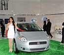 A model poses in front of a Fiat Punto car during the 10th Auto Expo in New Delhi on Tuesday. AFP Photo