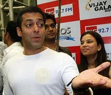 Indian Bollywood actor Salman Khan (L) gestures as he stands with admirers at a local radio station in Mumbai on January 6,