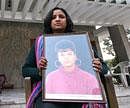 Aradhna Gupta holds a portrait of Ruchika outside the Girhotra residence in Panchkula. File photo AFP