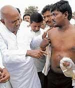 Former prime minister H D Deve Gowda with one of the farmers, who was allegedly attacked by NICE officials at Hemmigepura on Thursday. DH photo