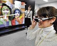 A Panasonic employee unveil a prototype model of the world's largest 152-inch plasma display panel. AFP