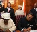 Botswana Education Minister Pelonomi Venson-Moitoi (L) and Indian High Commissioner to Botswana, Madgava Chandra signing the file in present of both vice president (Back) at Present's Office in Botswana on Saturday. PTI